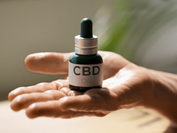 Hand som håller en cbd-olje flaska