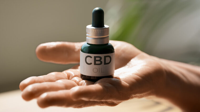 Hand som håller en cbd-olje flaska