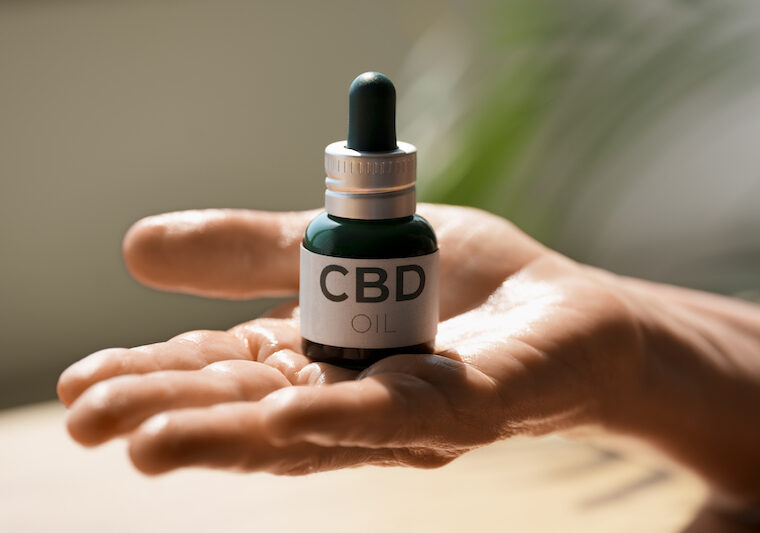 Hand som håller en cbd-olje flaska